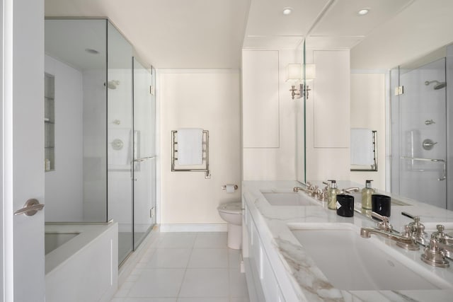 bathroom with tile patterned flooring, a stall shower, toilet, and a sink