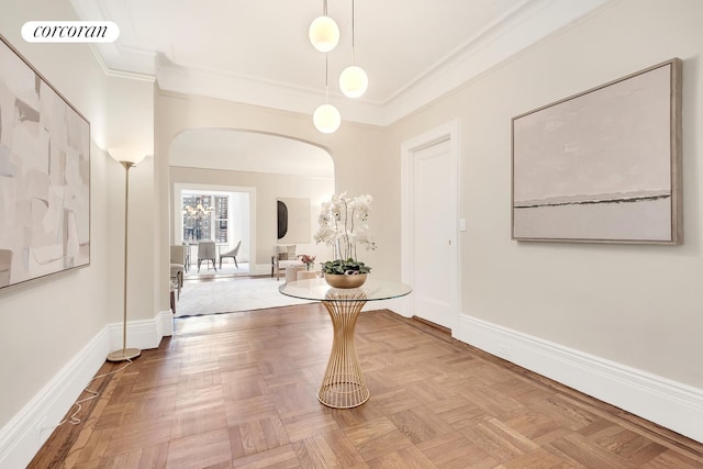 corridor with ornamental molding, visible vents, arched walkways, and baseboards