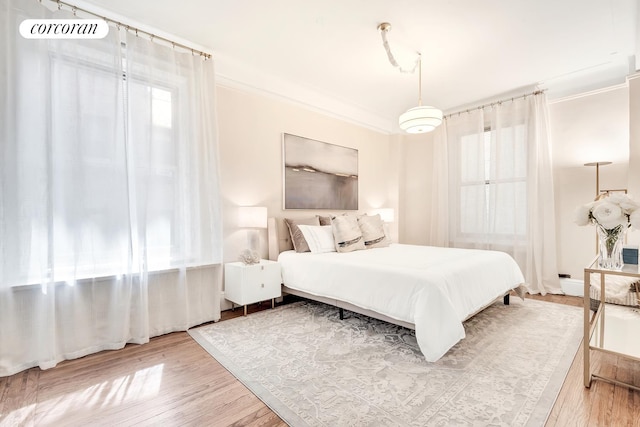 bedroom featuring crown molding and wood finished floors