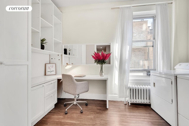 office space featuring radiator heating unit, wood finished floors, and washer and clothes dryer