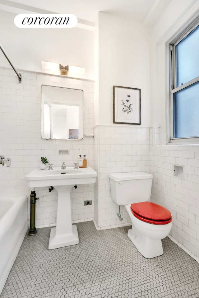 full bath featuring toilet, tile walls, washtub / shower combination, and tile patterned flooring