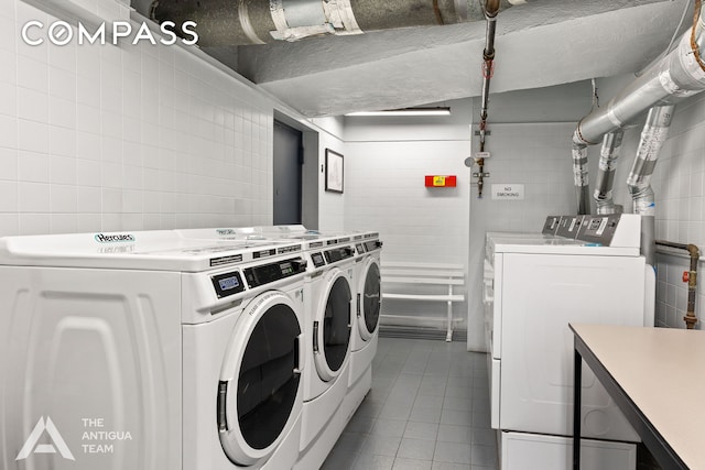152 E 35th St Unit 3A, New York City, NY 10016 - shared laundry room featuring washer and dryer, tile walls, and tile patterned floors
