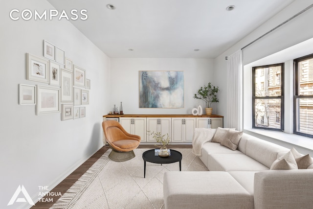 living area featuring recessed lighting, baseboards, and wood finished floors