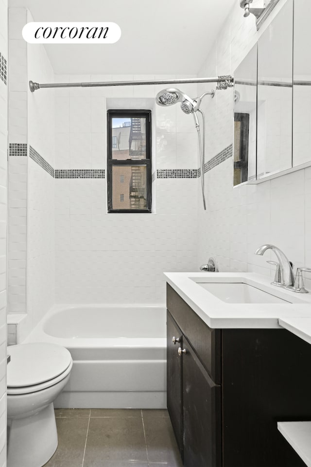 bathroom featuring toilet, tile walls, tile patterned flooring, tub / shower combination, and vanity