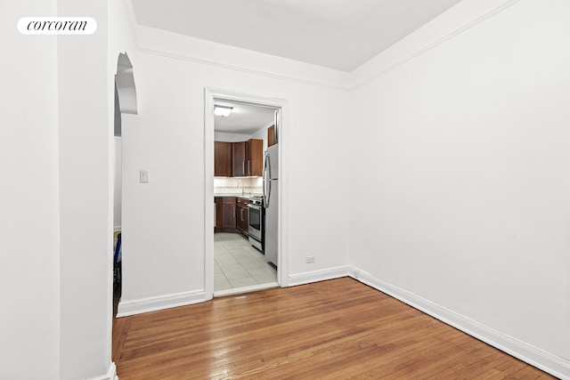 unfurnished room with light wood-style flooring and baseboards