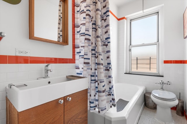 full bathroom featuring tile patterned flooring, toilet, vanity, wainscoting, and tile walls