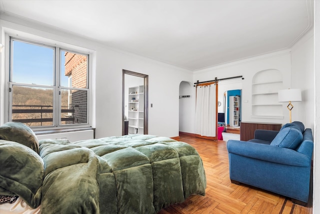 bedroom featuring a barn door, arched walkways, baseboards, and ornamental molding