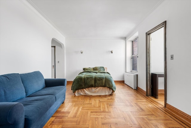 bedroom featuring arched walkways, radiator heating unit, baseboards, and ornamental molding