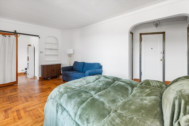 bedroom featuring arched walkways, a barn door, and ornamental molding