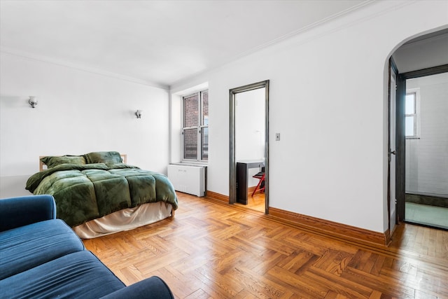 bedroom with arched walkways, radiator heating unit, baseboards, and ornamental molding