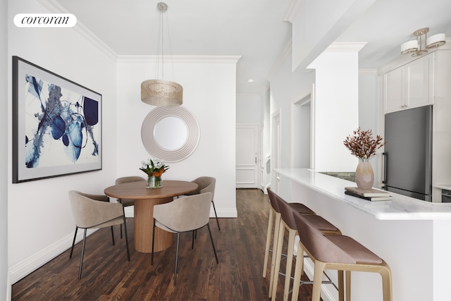 dining room featuring crown molding, dark wood-style floors, visible vents, and baseboards