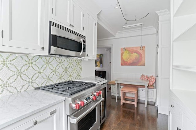 400 E 59th St Unit 4C, New York City, NY 10022 - kitchen featuring stainless steel appliances, white cabinetry, dark wood-style floors, decorative backsplash, and crown molding