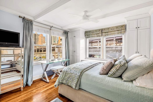 bedroom featuring crown molding, beamed ceiling, multiple windows, and light wood-type flooring