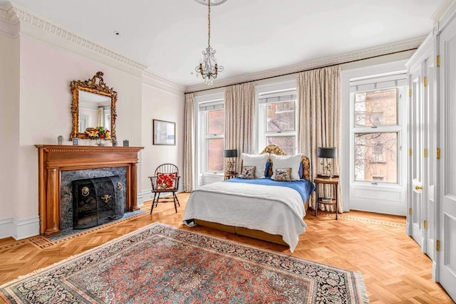 bedroom with a fireplace, a notable chandelier, baseboards, and crown molding