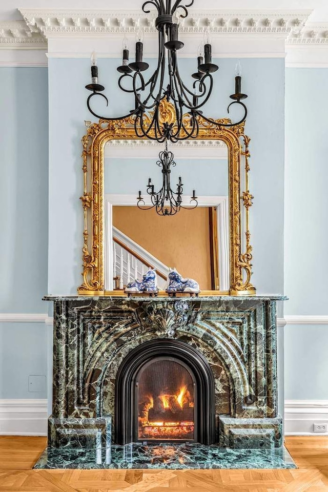details with crown molding, wood finished floors, a notable chandelier, and baseboards