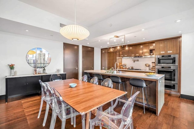 dining room with dark wood-style floors, visible vents, recessed lighting, and baseboards