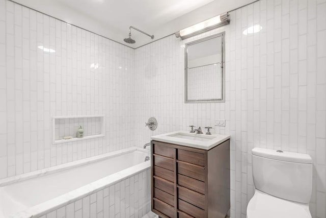 bathroom featuring vanity, tile walls, toilet, and tiled shower / bath