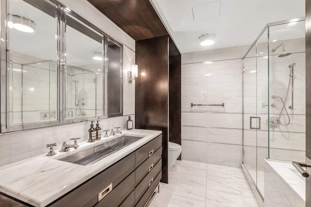 bathroom featuring vanity, tile walls, marble finish floor, and a stall shower