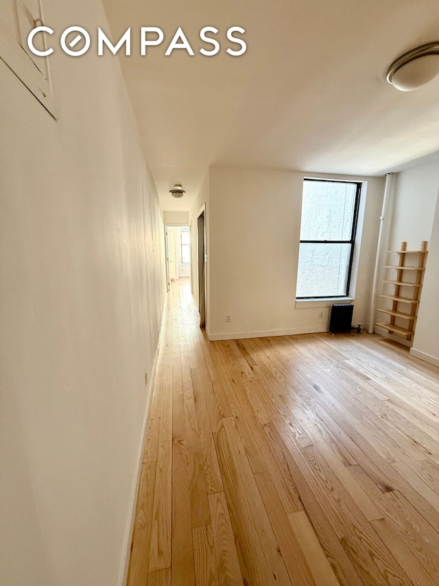 hallway with baseboards and light wood-style flooring