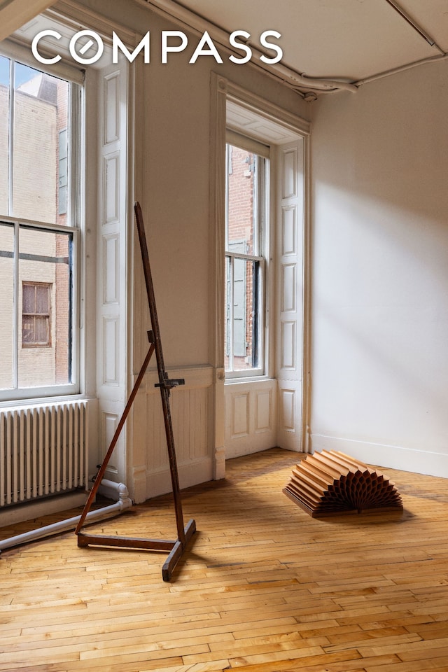 515 Broadway Unit 4B, New York City, NY 10012 - empty room with radiator, hardwood / wood-style floors, and baseboards
