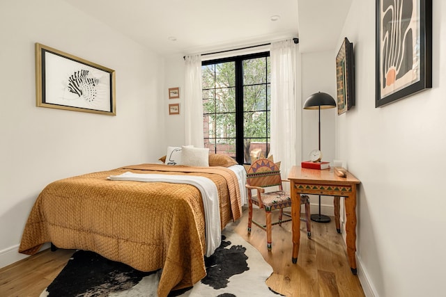 bedroom with baseboards and wood finished floors