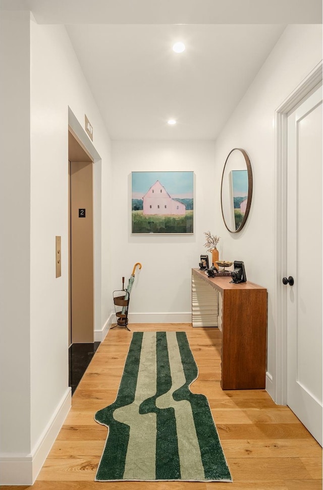 corridor featuring elevator, wood finished floors, recessed lighting, and baseboards