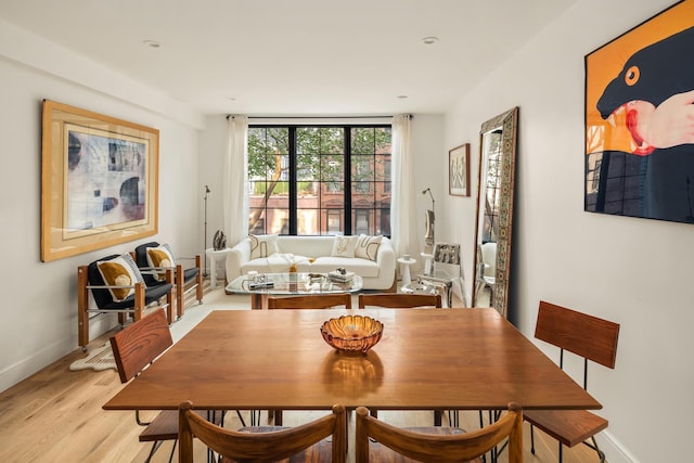 dining room featuring light wood-style flooring and baseboards