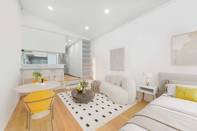 bedroom featuring lofted ceiling, recessed lighting, baseboards, and light wood finished floors