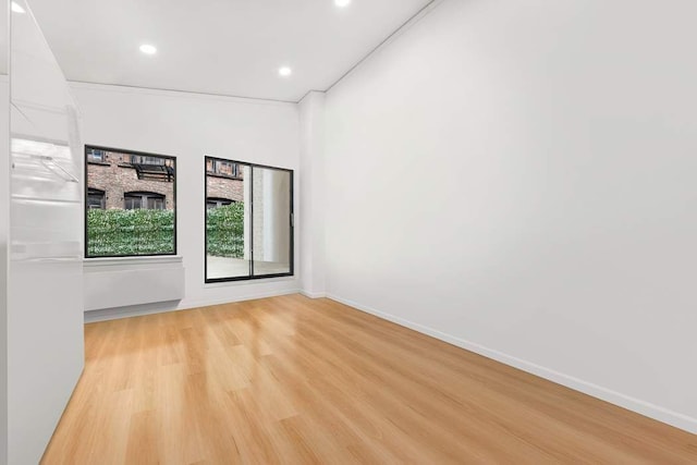 spare room featuring recessed lighting, light wood-style flooring, and baseboards