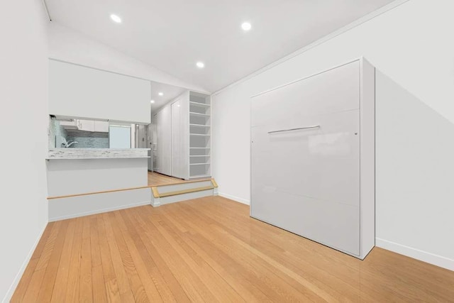 unfurnished living room featuring recessed lighting, light wood-style floors, and baseboards