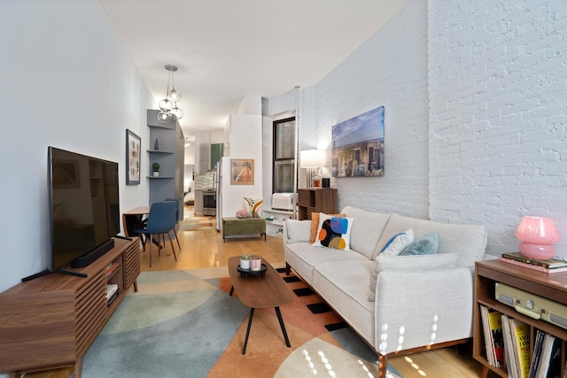 living room with wood finished floors and brick wall