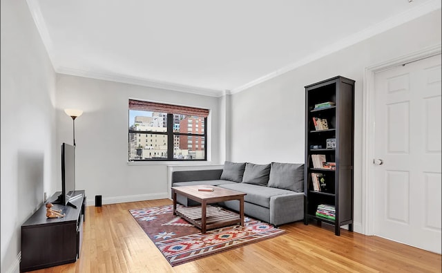 living room with light wood-style flooring, baseboards, and ornamental molding