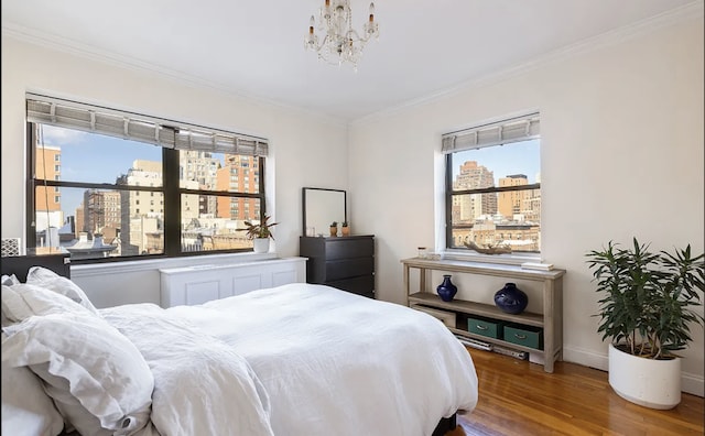 bedroom featuring crown molding, a view of city, multiple windows, and wood finished floors