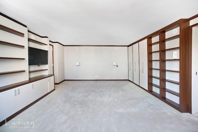 interior space featuring crown molding, light colored carpet, and baseboards