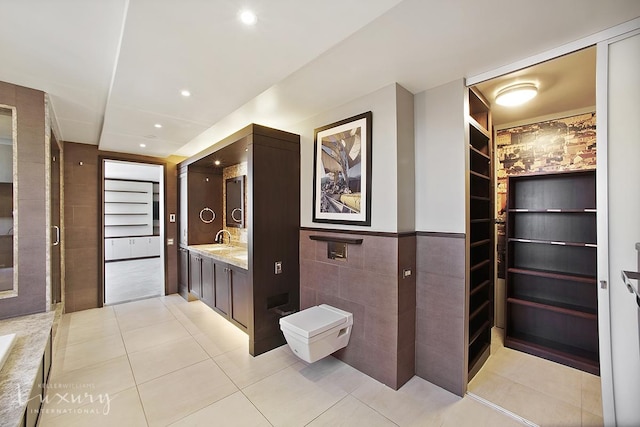 bathroom featuring tile patterned floors, recessed lighting, tile walls, wainscoting, and vanity