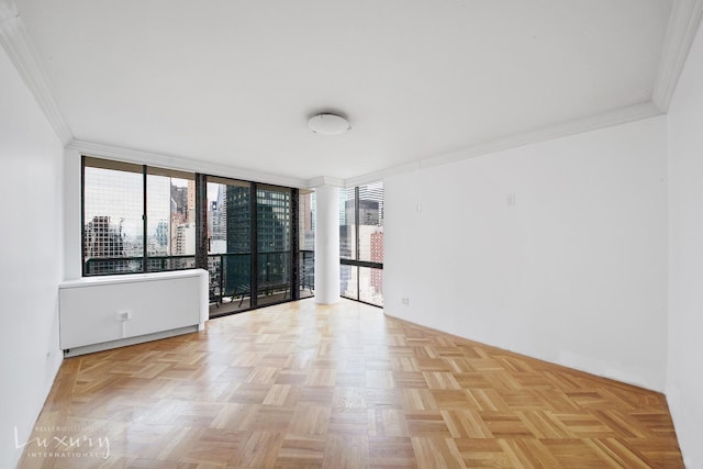spare room with expansive windows and ornamental molding