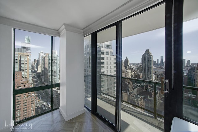 interior space with baseboards, a view of city, a healthy amount of sunlight, and ornamental molding