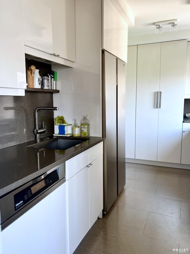 kitchen with open shelves, freestanding refrigerator, a sink, white cabinets, and dishwasher