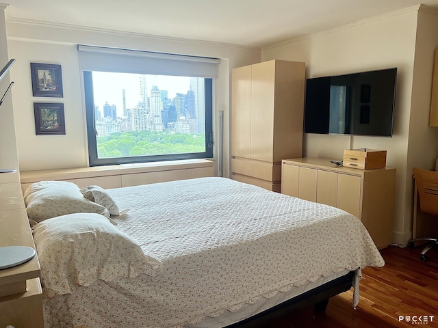 bedroom featuring wood finished floors and ornamental molding