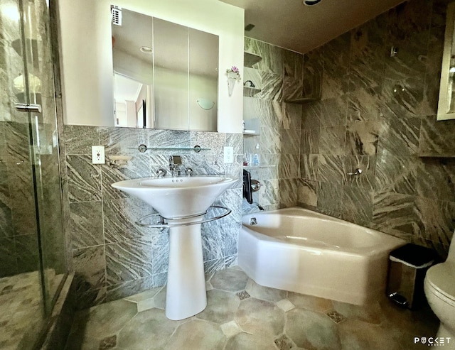 bathroom with tile walls, toilet, tub / shower combination, and visible vents