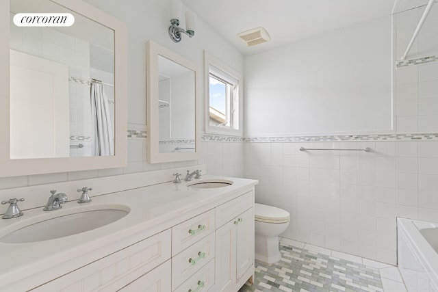 full bathroom with toilet, tile walls, a shower with curtain, and a sink