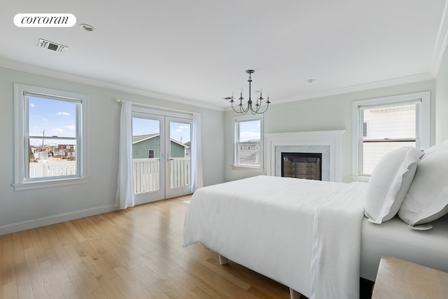 bedroom with light wood-type flooring, visible vents, access to exterior, and ornamental molding