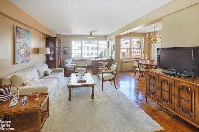 living room with a chandelier, parquet floors, and radiator heating unit