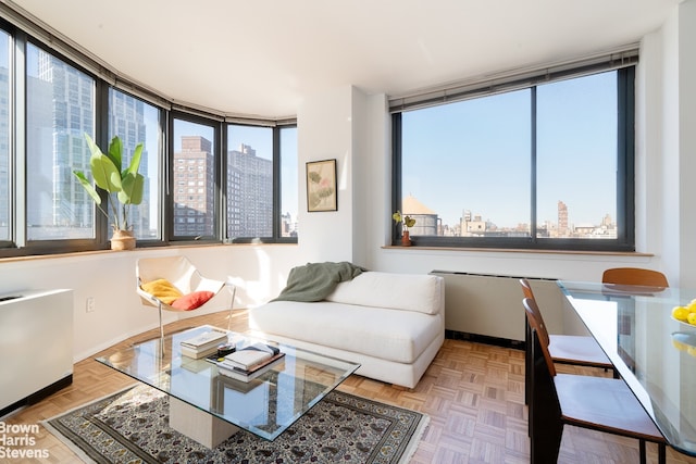 living room featuring a view of city, radiator heating unit, and baseboards