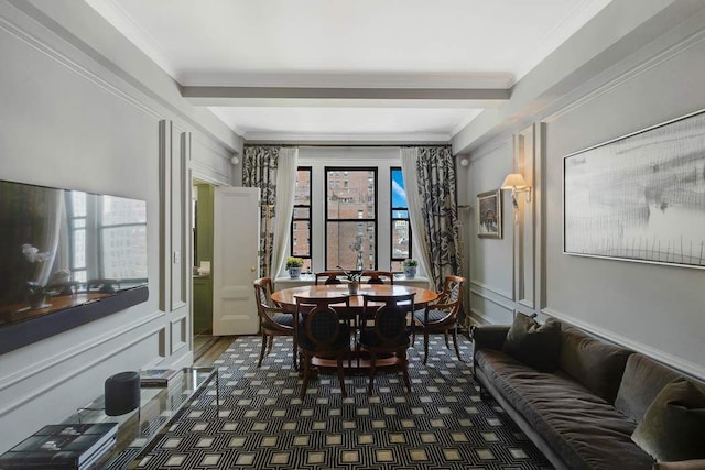 dining space featuring a decorative wall, wood finished floors, and ornamental molding