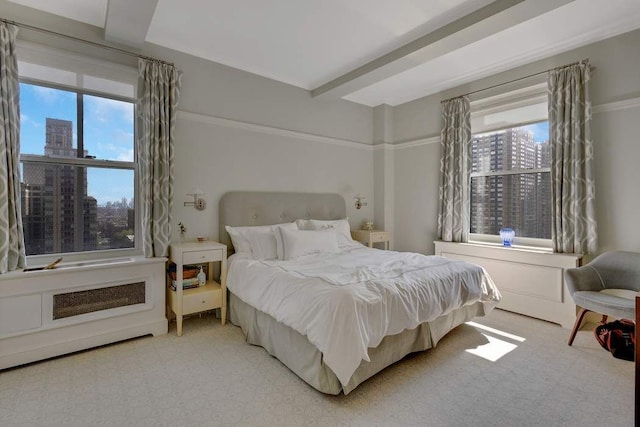 bedroom with beam ceiling, a view of city, and light carpet