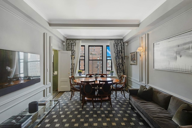 dining space with a decorative wall, wood finished floors, and ornamental molding