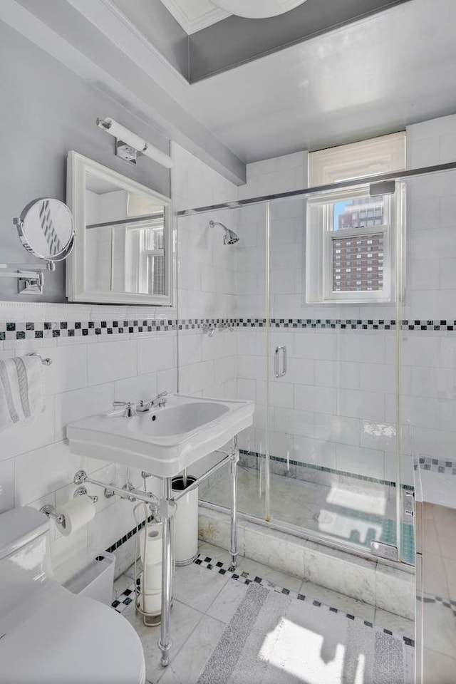 bathroom with a shower stall, tile walls, and toilet