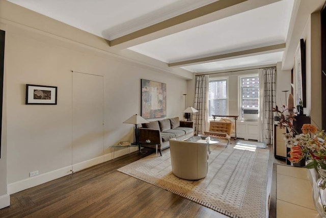 living area with beam ceiling, ornamental molding, baseboards, and wood finished floors