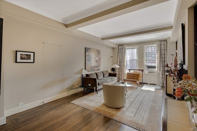 living area featuring baseboards, beam ceiling, wood finished floors, and ornamental molding